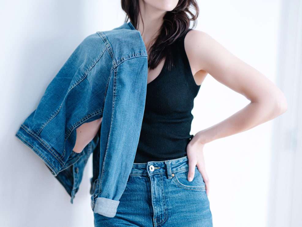 Portrait mode en lumière naturelle d’une jeune femme en jeans et débardeur noir, réalisé par un photographe professionnel à Montréal